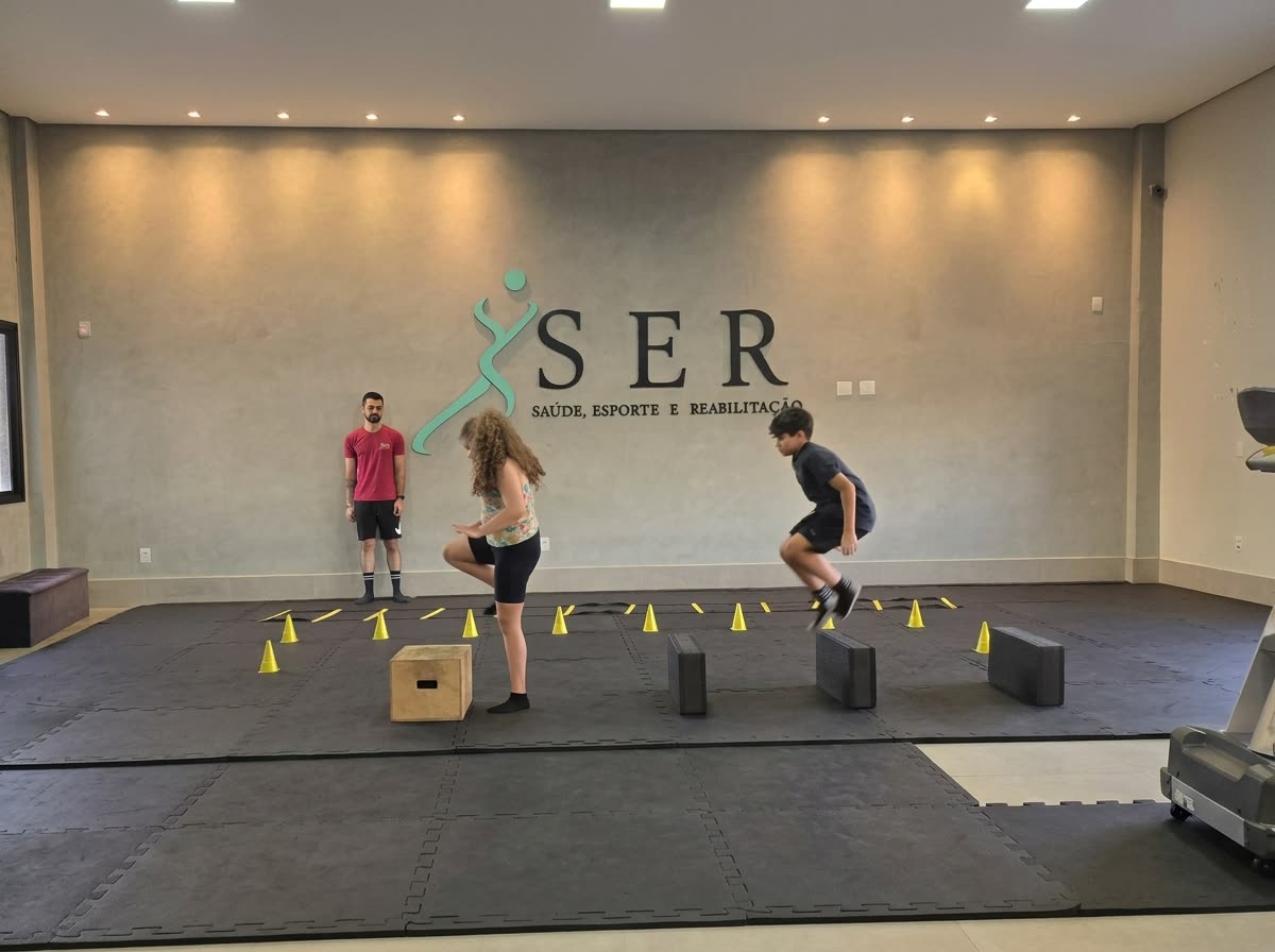 Crianças da turma kids da S.E.R saltando cones e blocos, com o treinador acompanhando
